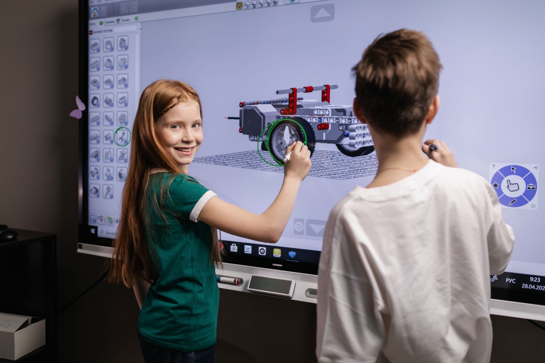 Children working together at a large interactive classroom display